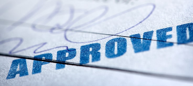 An "approved" stamThe word “approved” is stamped across a document. A step-by-step guide will help you be approved for a business license.p on a document.