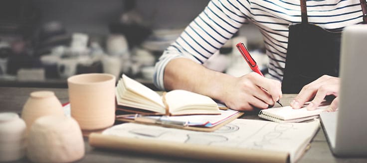 A woman taking notes on how to value a small business.