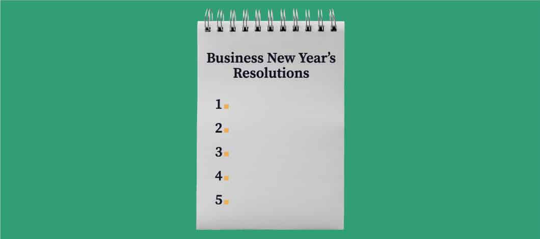 A spiral notepad with the words "Business New Year's Resolutions" and the numbers 1 through 5