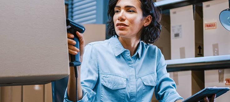 A warehouse employee scans a shipment to update stock levels in the company's inventory management system.