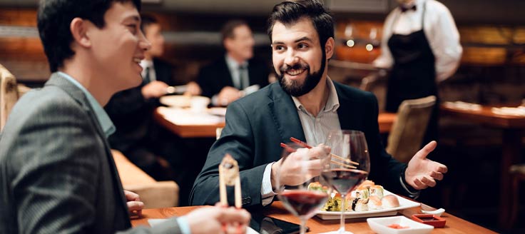 Two men eat in a restaurant as they have a business dinner.