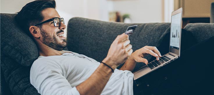 A man uses a credit card to complete an online purchase. Customers enjoy the convenience and immediacy of BOPIS.