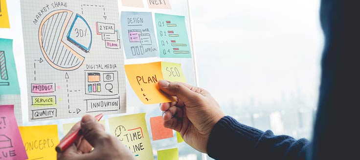 A business person shares ideas via papernote strategy on a glass office wall.