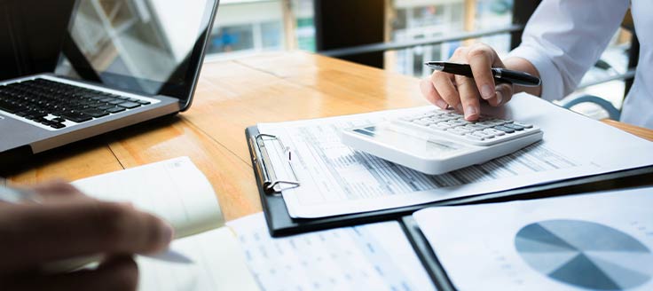 Two people work at a desk in an office.