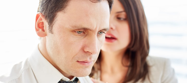 A woman sexually harassing a male coworker in the workplace.