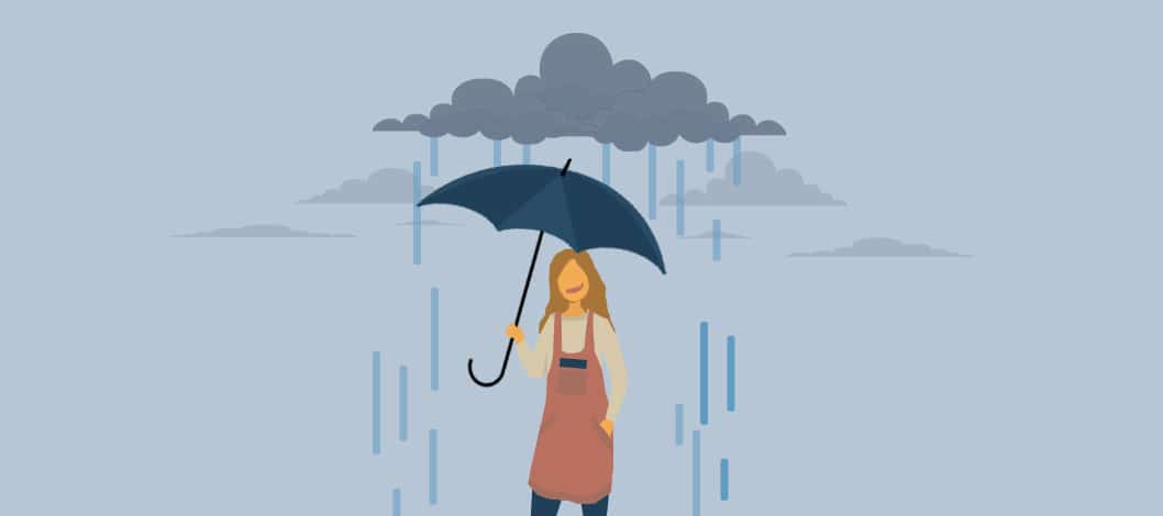 A small business owner smiles as the umbrella she’s holding is shielding her from the rain falling from a dark cloud.