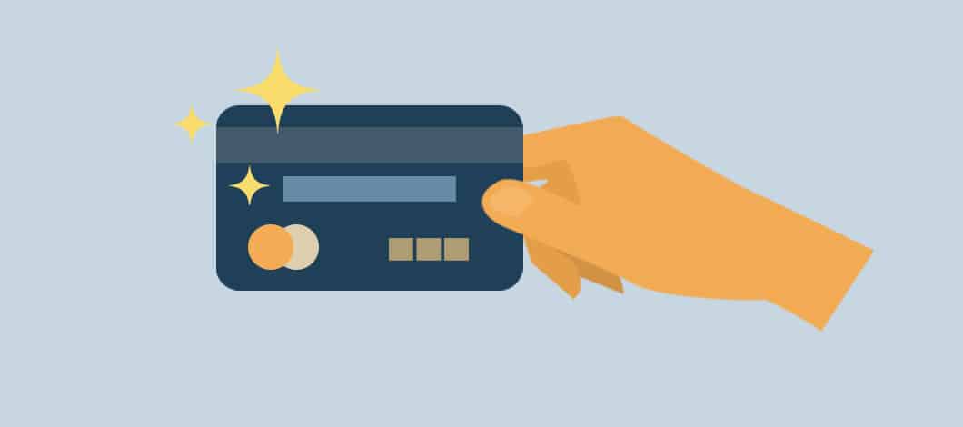 A hand holds a business credit card that sparkles.