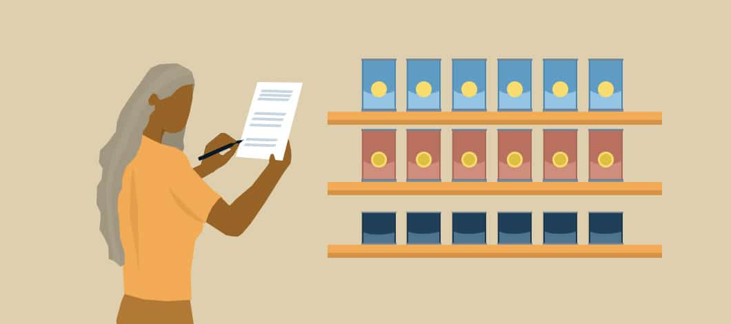 A businesswoman stands next to shelves filled with cans. She is taking stock of her inventory, jotting notes on her clipboard.