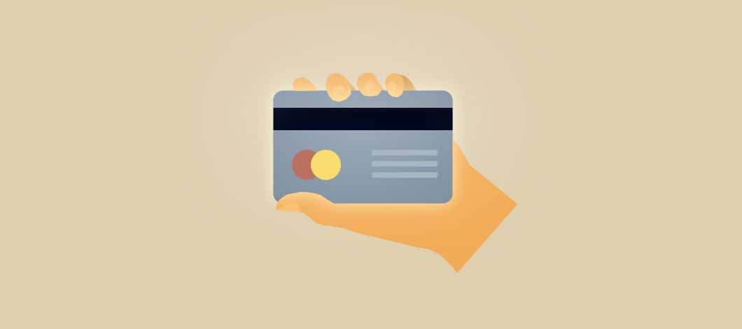 A hand holds a credit card.