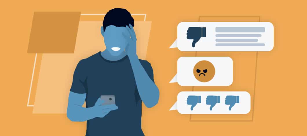 An astonished person holds a smartphone that is emitting text balloons featuring thumbs down and an angry face emoji.
